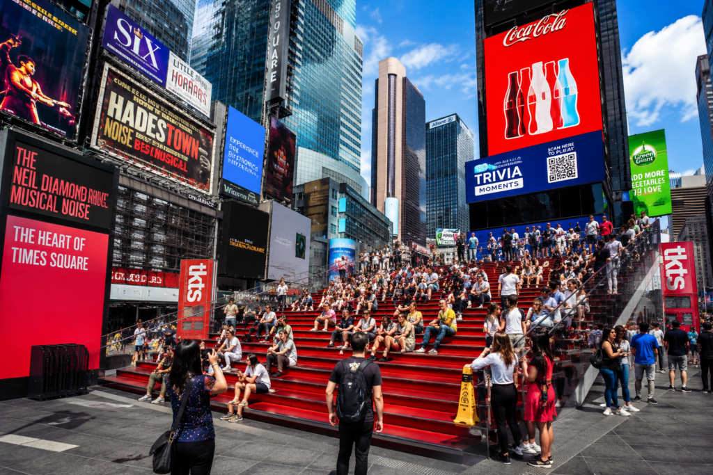 Visitors relaxing on the famous  things to do in Times SquareRed Steps at Duffy Square in Times Square, New York City