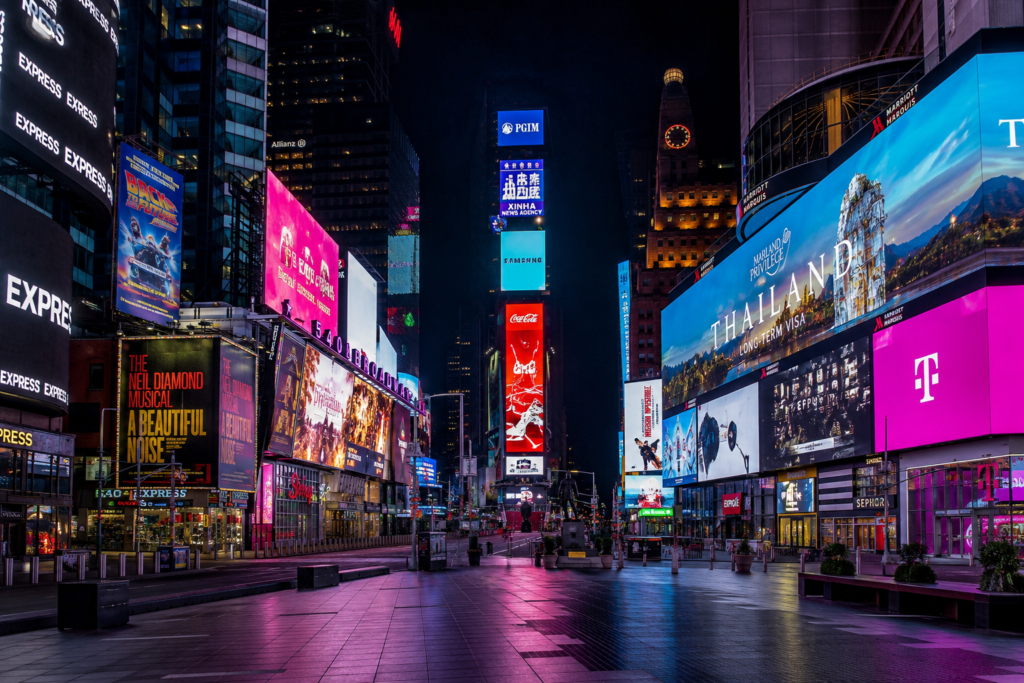 Times Square New York at night with bright digital billboards and an empty pedestrian plaza